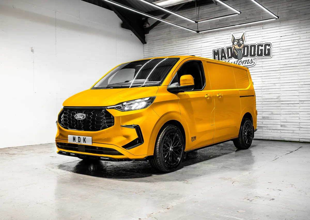 Yellow Ford Transit Custom with body kit and black alloys in the MDK studio